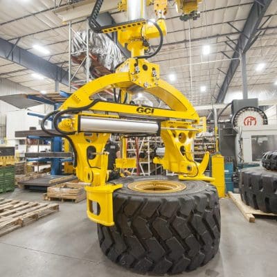 Overhead mount GCI manipulator lifting 3,000 lb Caterpillar tires of varying sizes