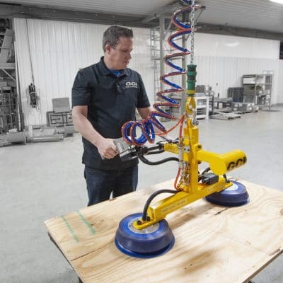 Operator picks up a board with dual vacuum cupped manipulator from an overhead trolley