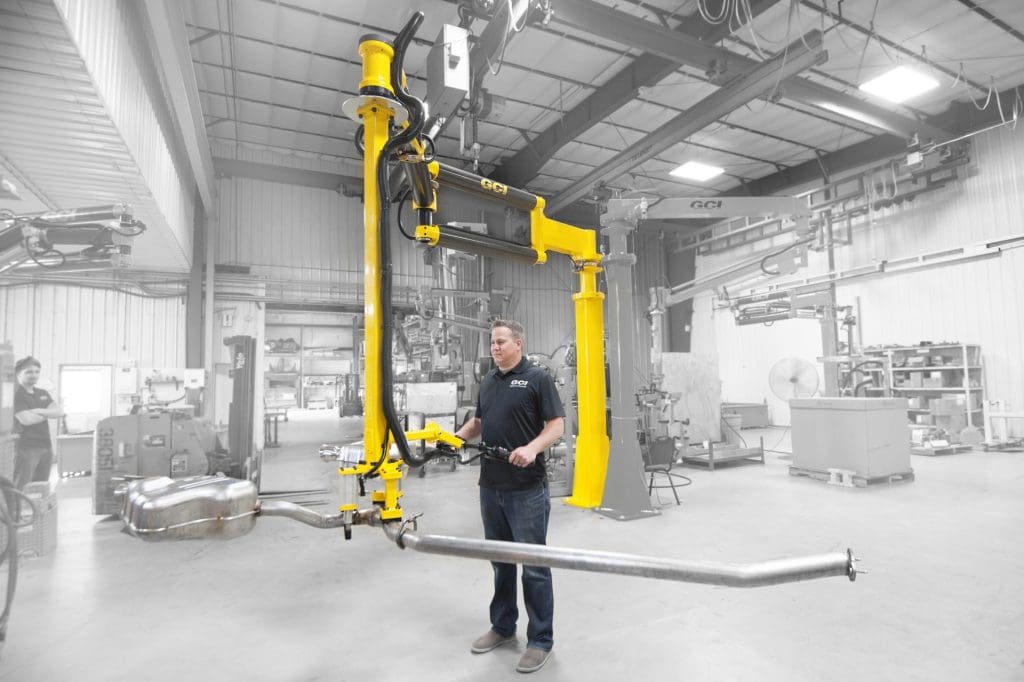 Man lifts heavy exhaust with a GCI industrial manipulator
